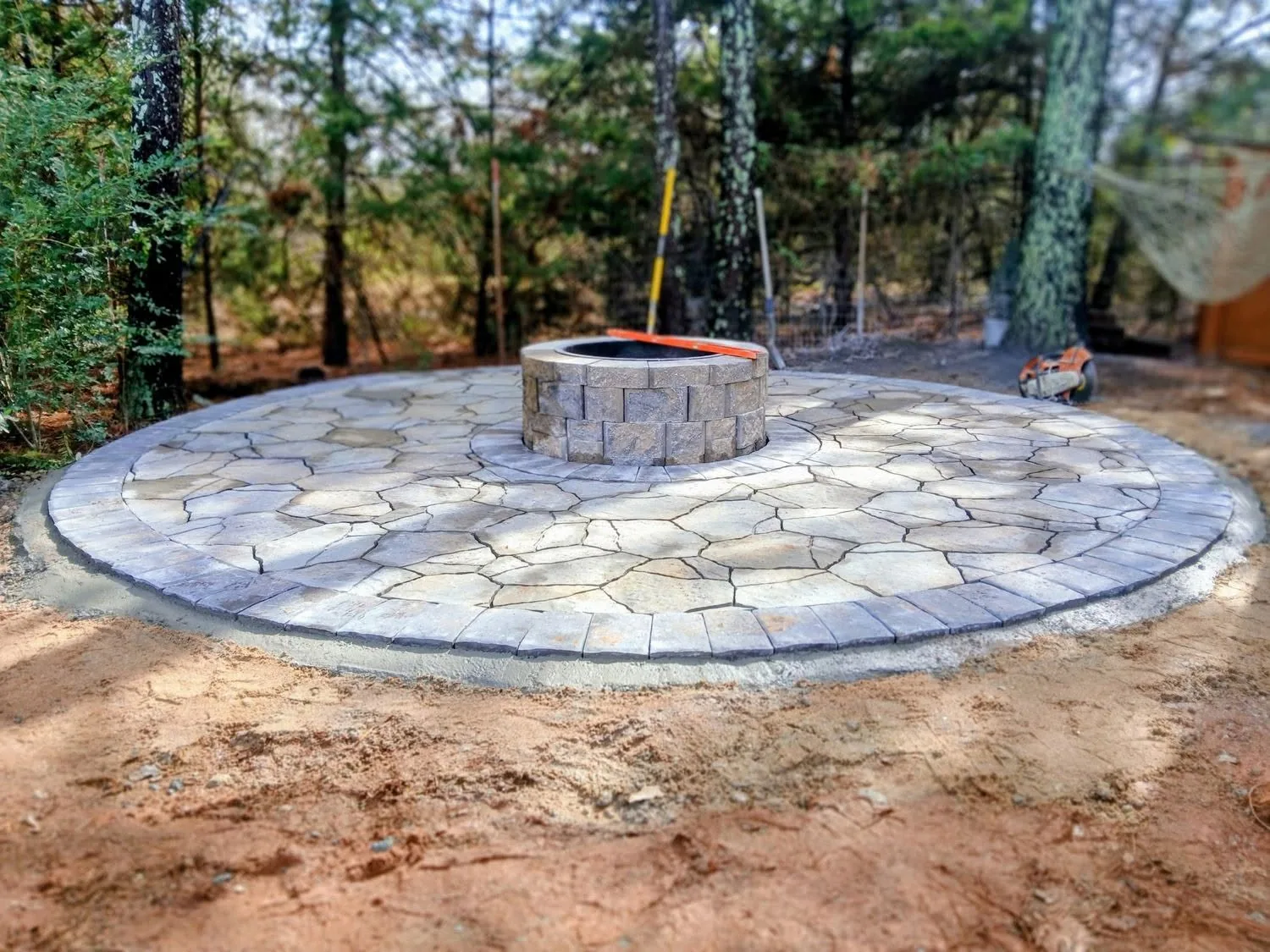 Circular paver patio block fire pit wooded yard