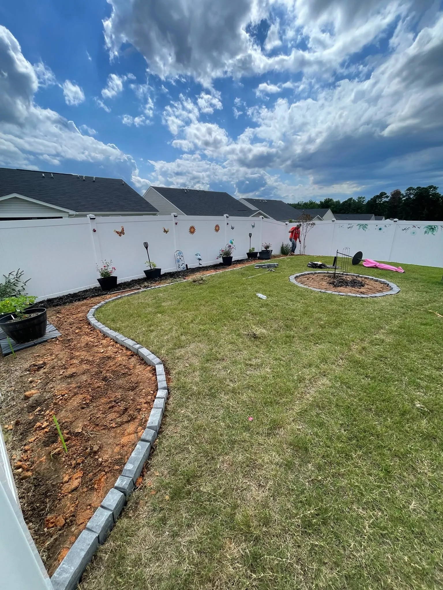 Curved block edging circular bed fenced backyard SC