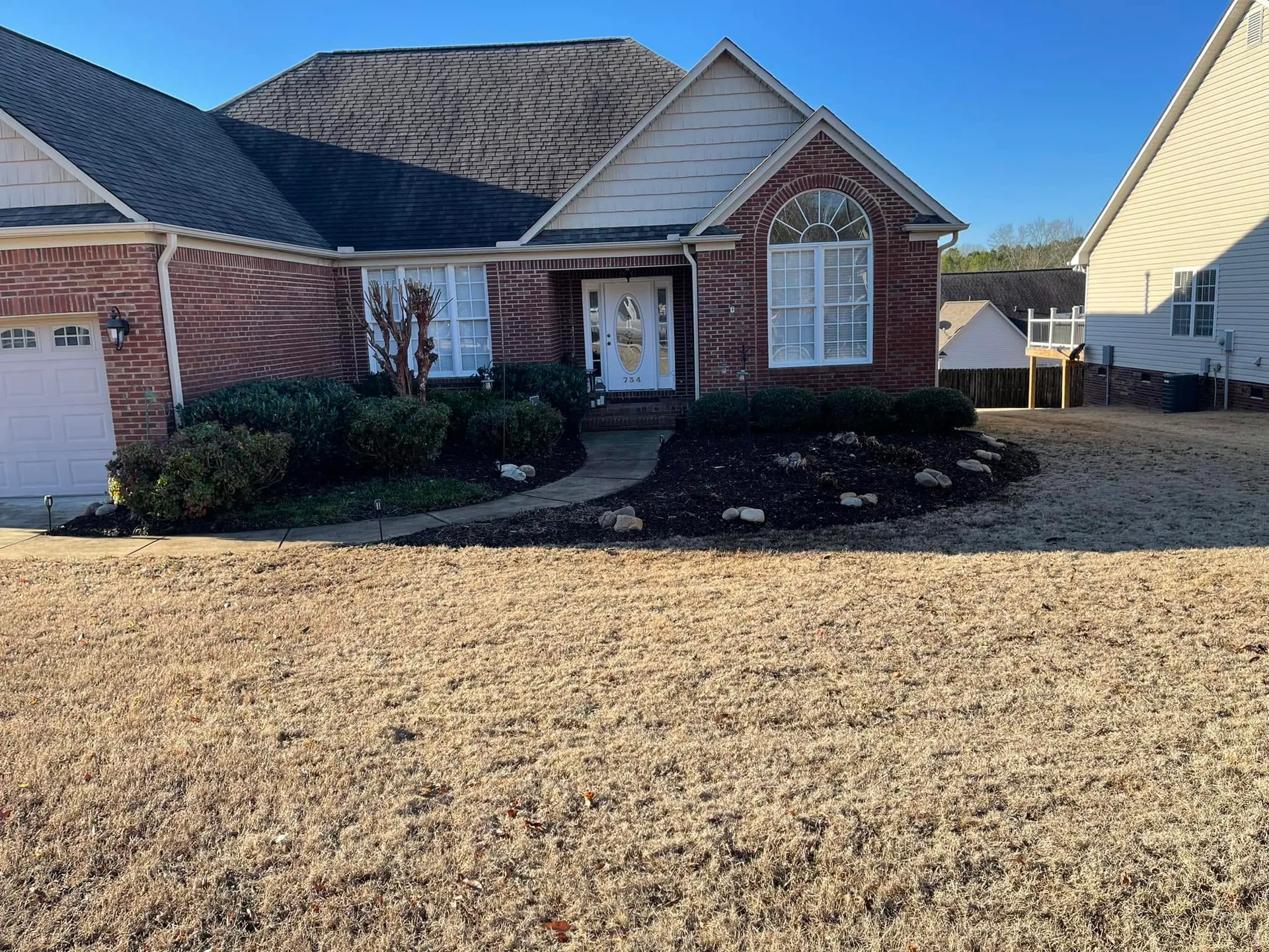 Fresh mulch front bed river rock brick home