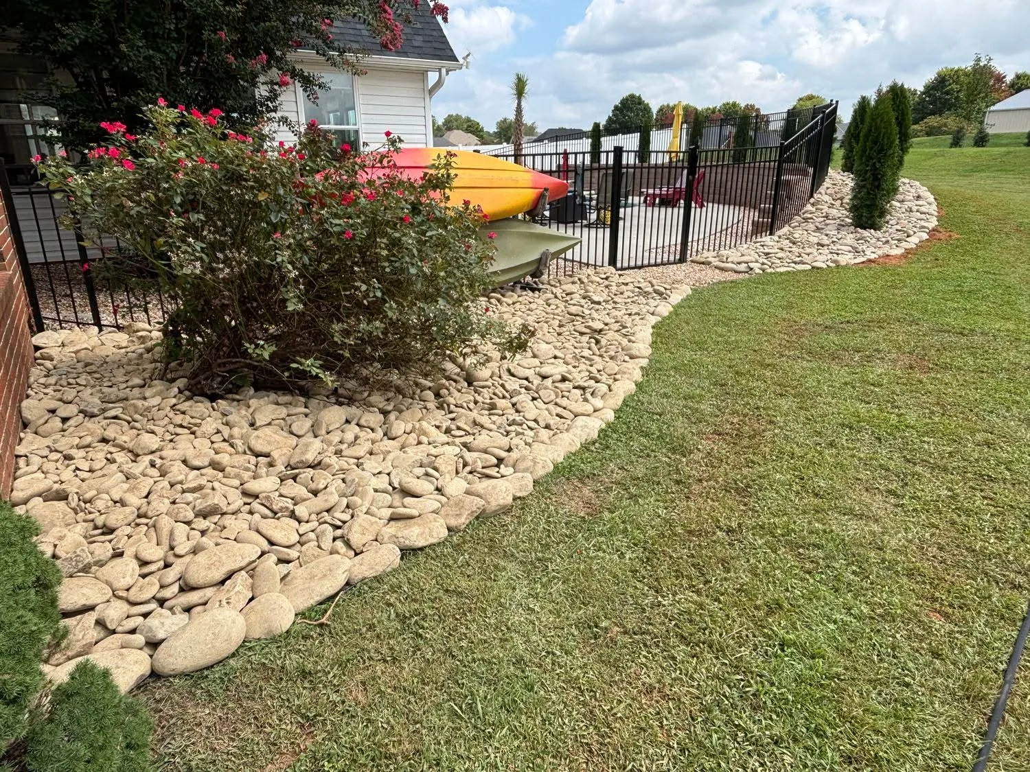 Kayak storage river rock bed arborvitae lawn