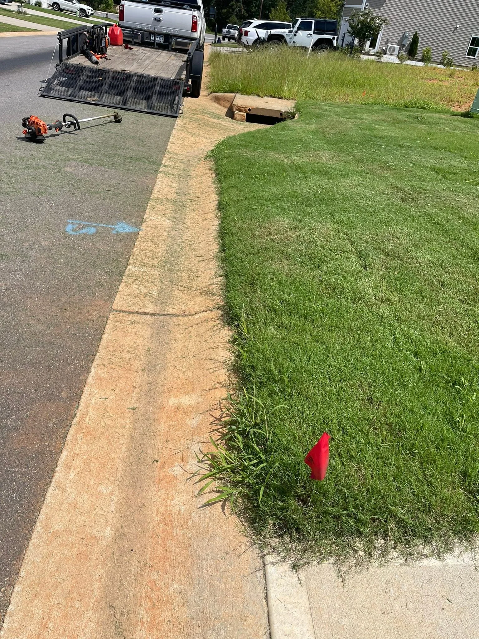 Mowed lawn curb edge trimmer trailer storm drain.959a8919