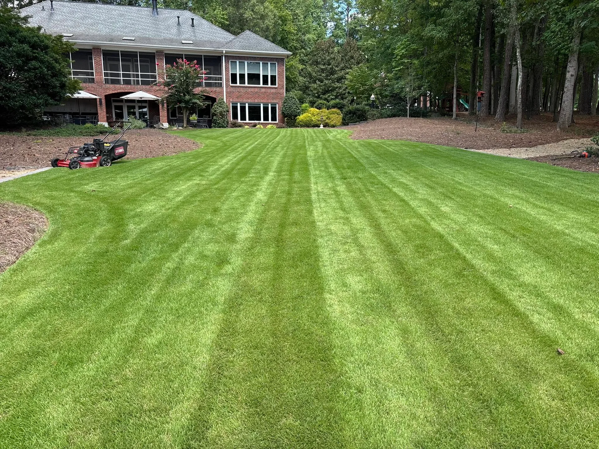 Striped mowed backyard lawn brick home push mower.3b2bcacd