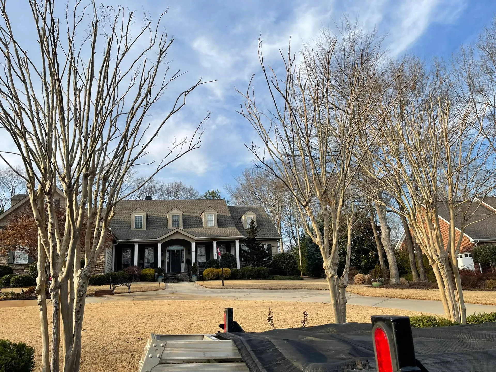 Trailer view bare crape myrtles dormer home winter